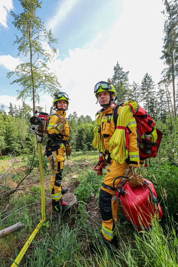 Feuerwehrleute im Einsatz bei Waldbrand mit Schlauchpaket. | © GH