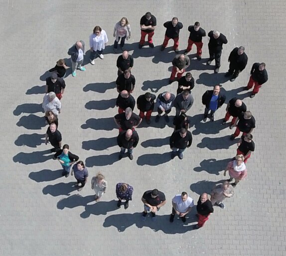 GH Mitarbeiter sind in Form des Logos aufgestellt | © GH